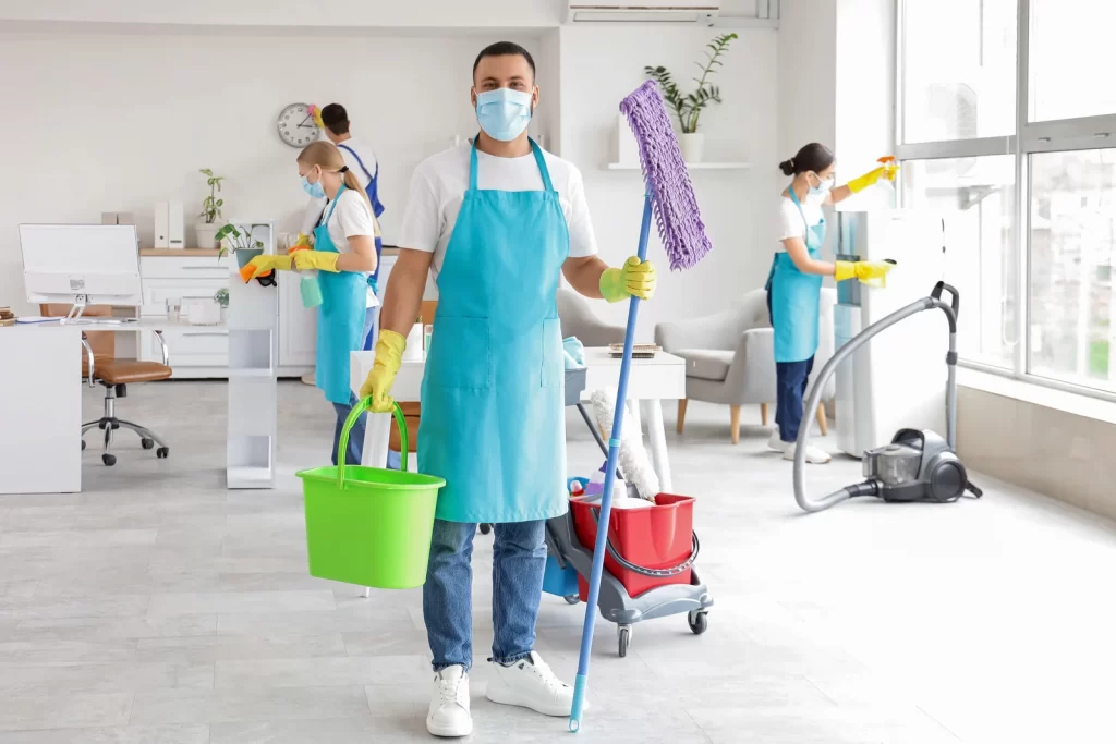 Commercial cleaning Surrey team disinfecting and cleaning a modern office space with professional equipment and safety gear.